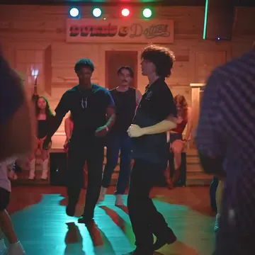 Line dancers under green stage light