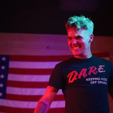 A grinning guest in front of the American flag