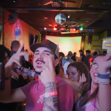 Guests cheer toward the camera on a crowded floor